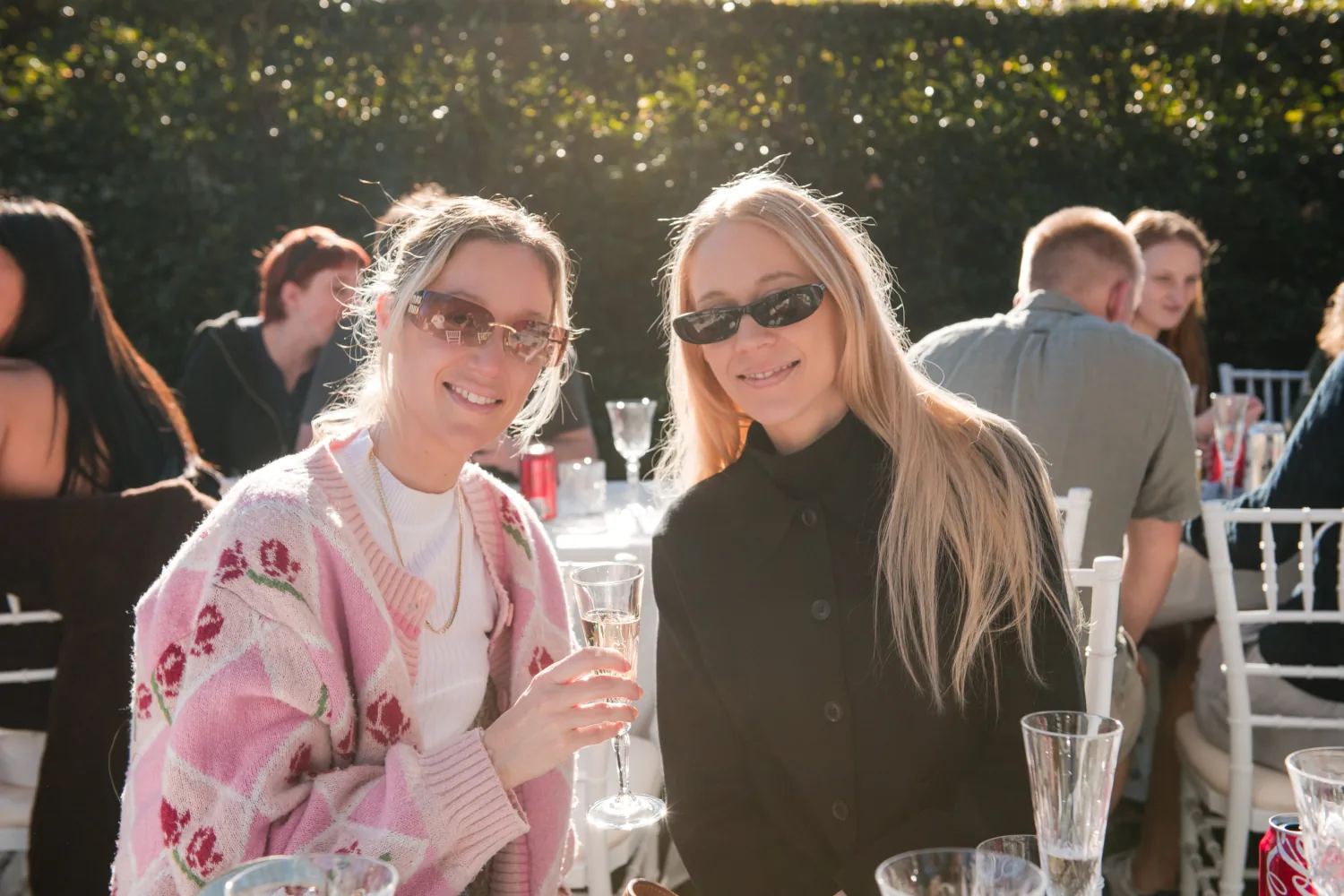 Two guests posing together in the afternoon light